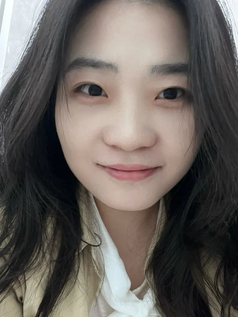 室内的自拍，长发披肩，米色外套配白色衬衫，对着镜头微笑