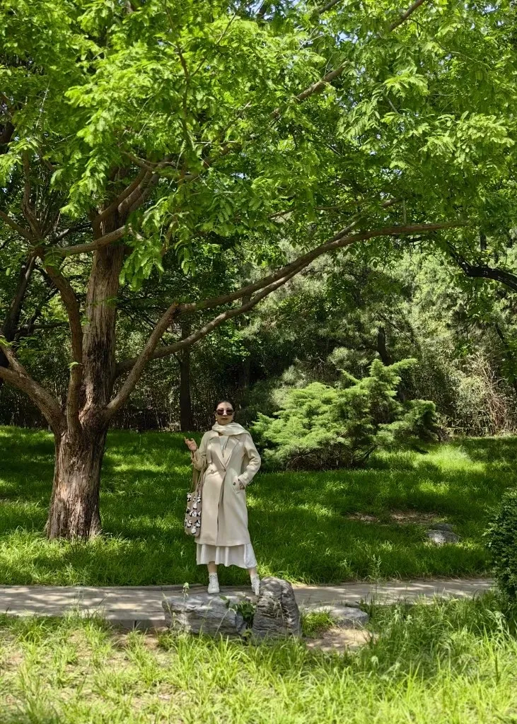 同一棵树下的另一张全身照，画面里草地与松树的绿色更满